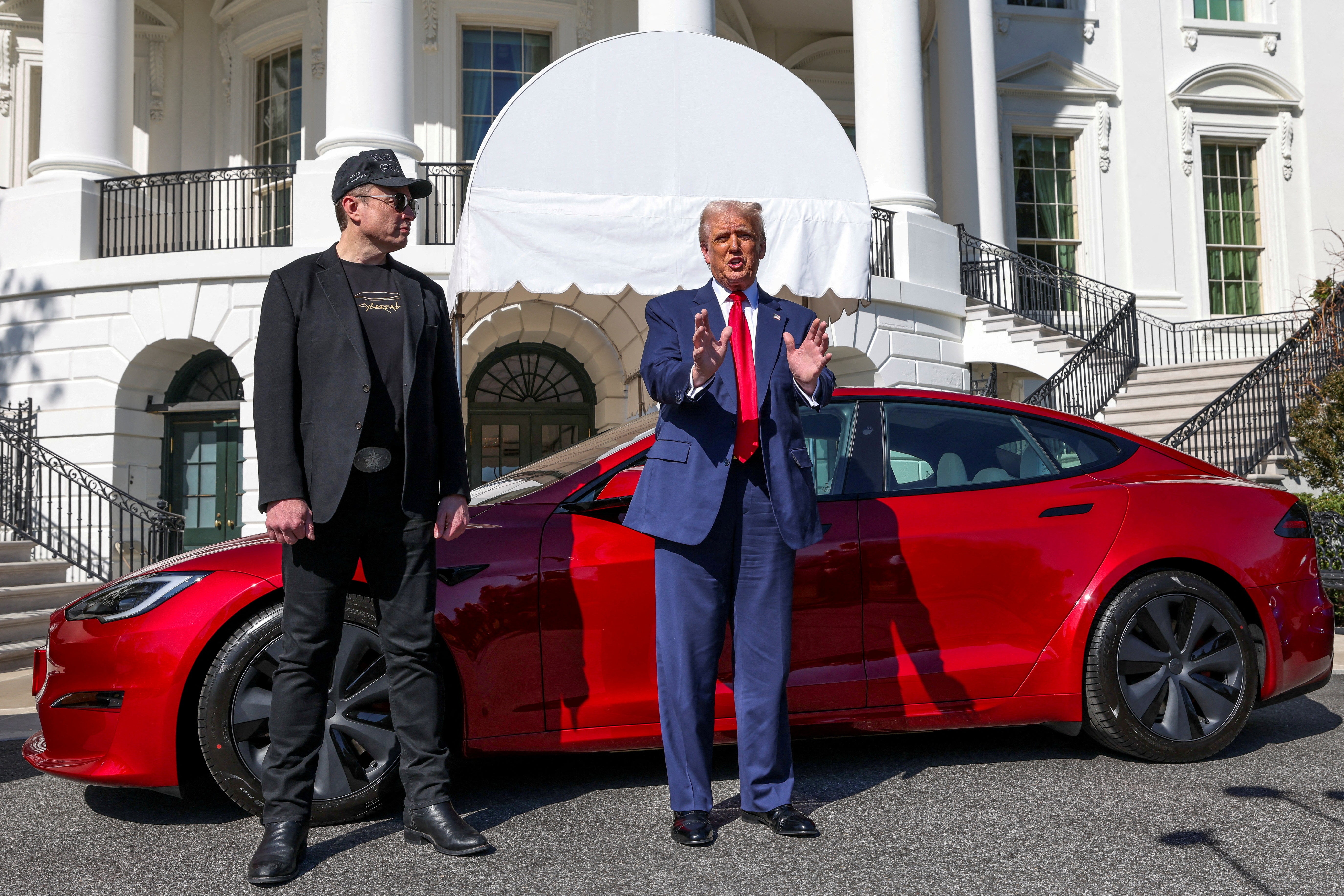 Musk and Trump posing with a Tesla at the White House on March 11 2025